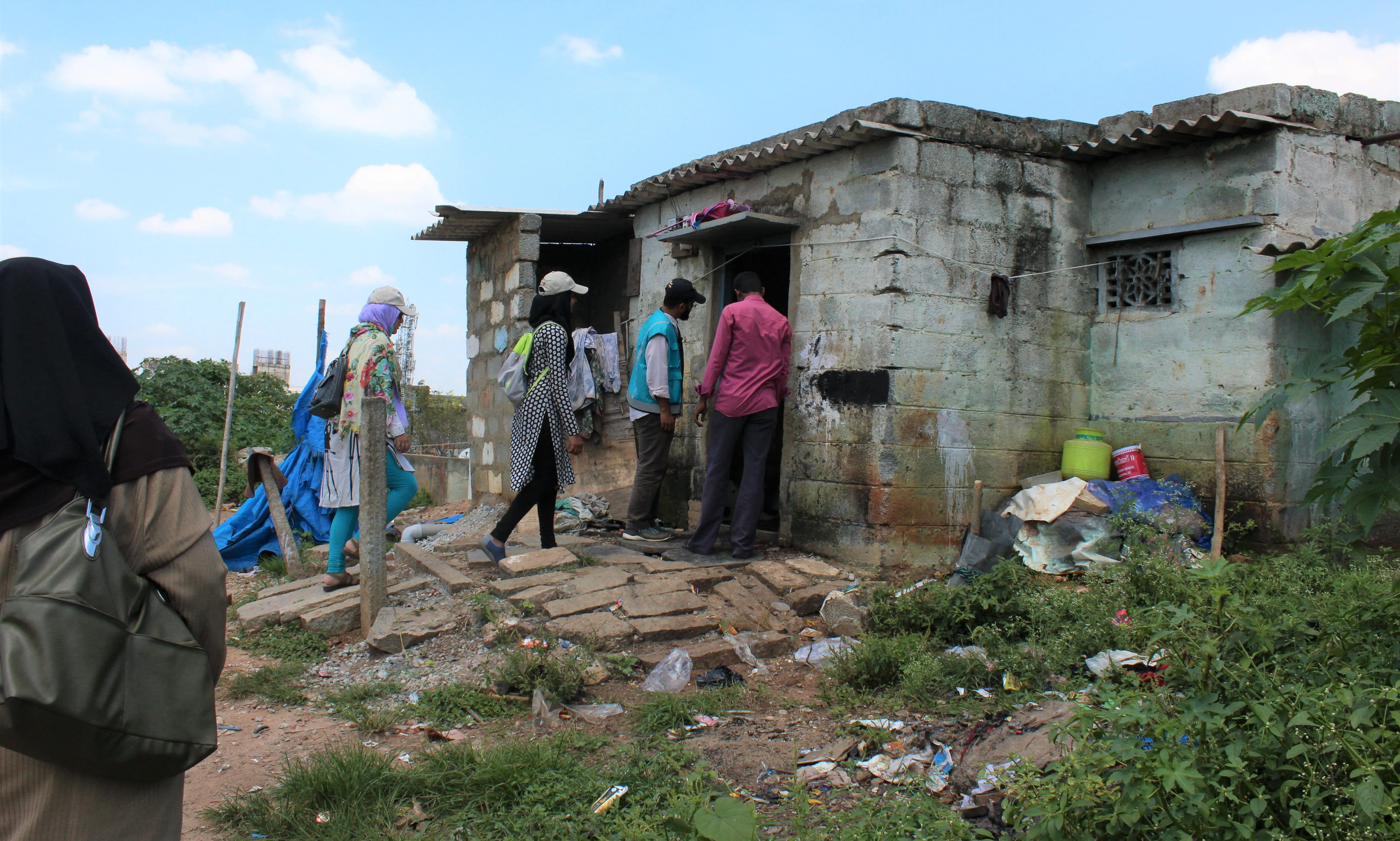 Neighborhood homes along a narrow lane with residents outside.