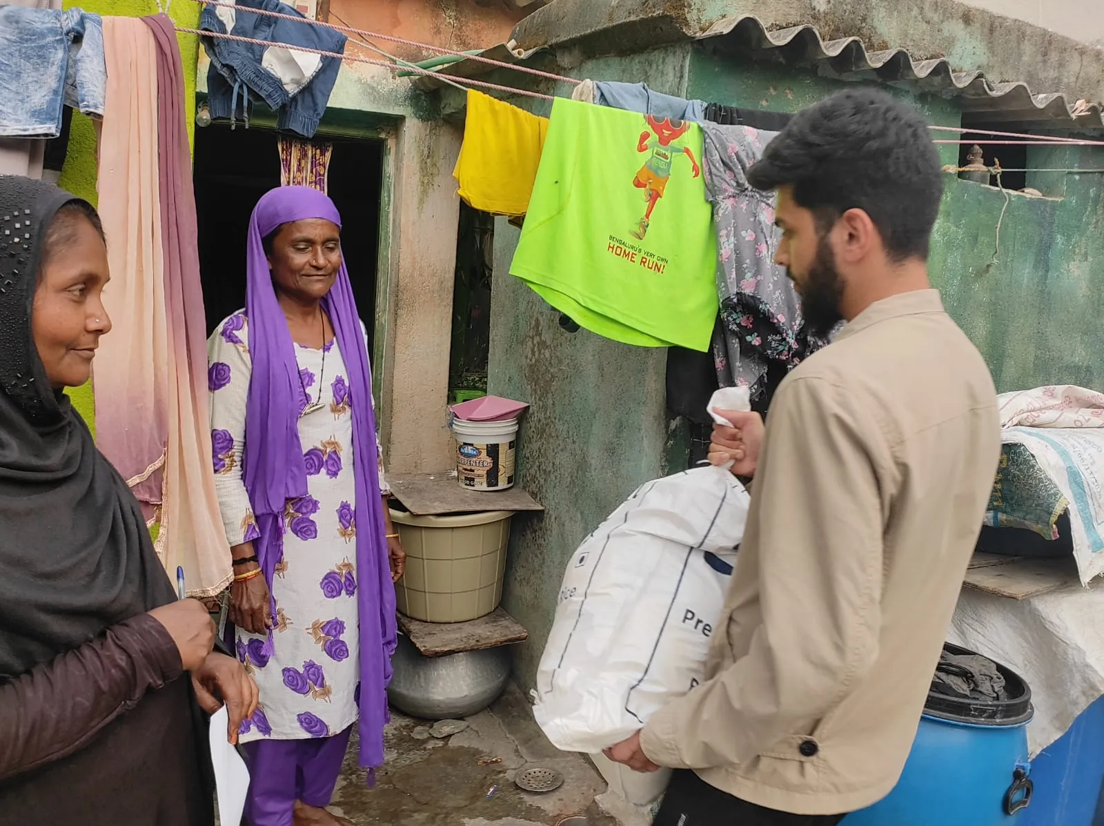 Community outreach worker delivering a relief bundle to a family.