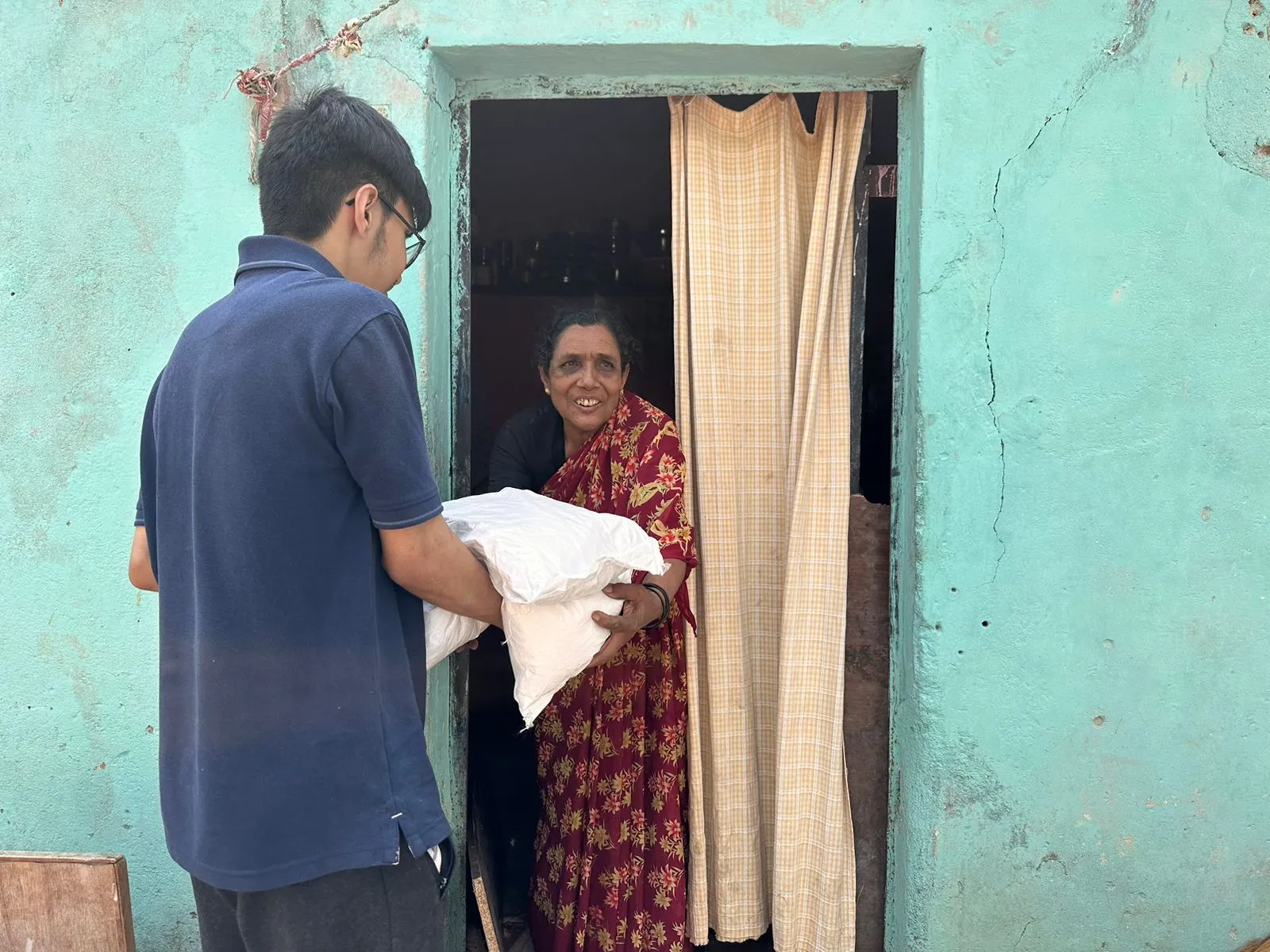 Program lead speaking with a caregiver at a doorway.