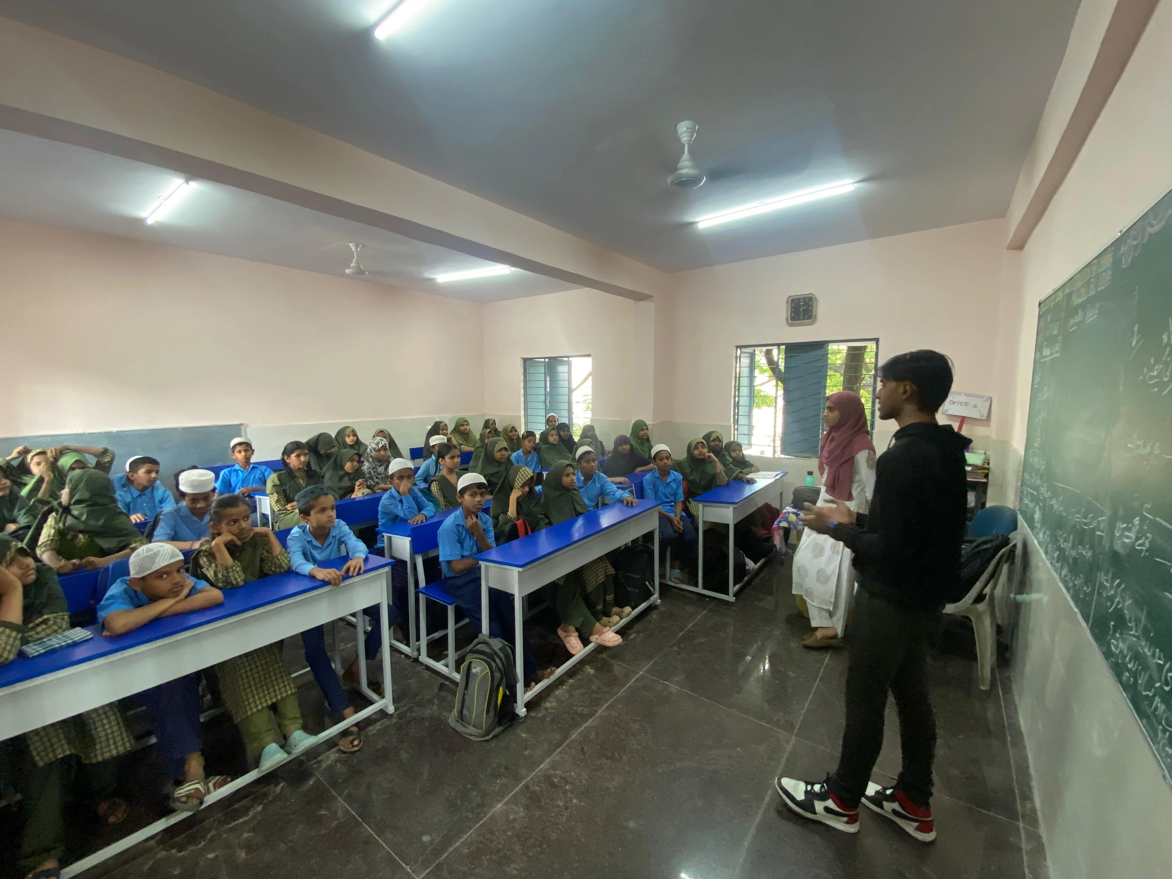 Students seated in a classroom listening to a lesson.