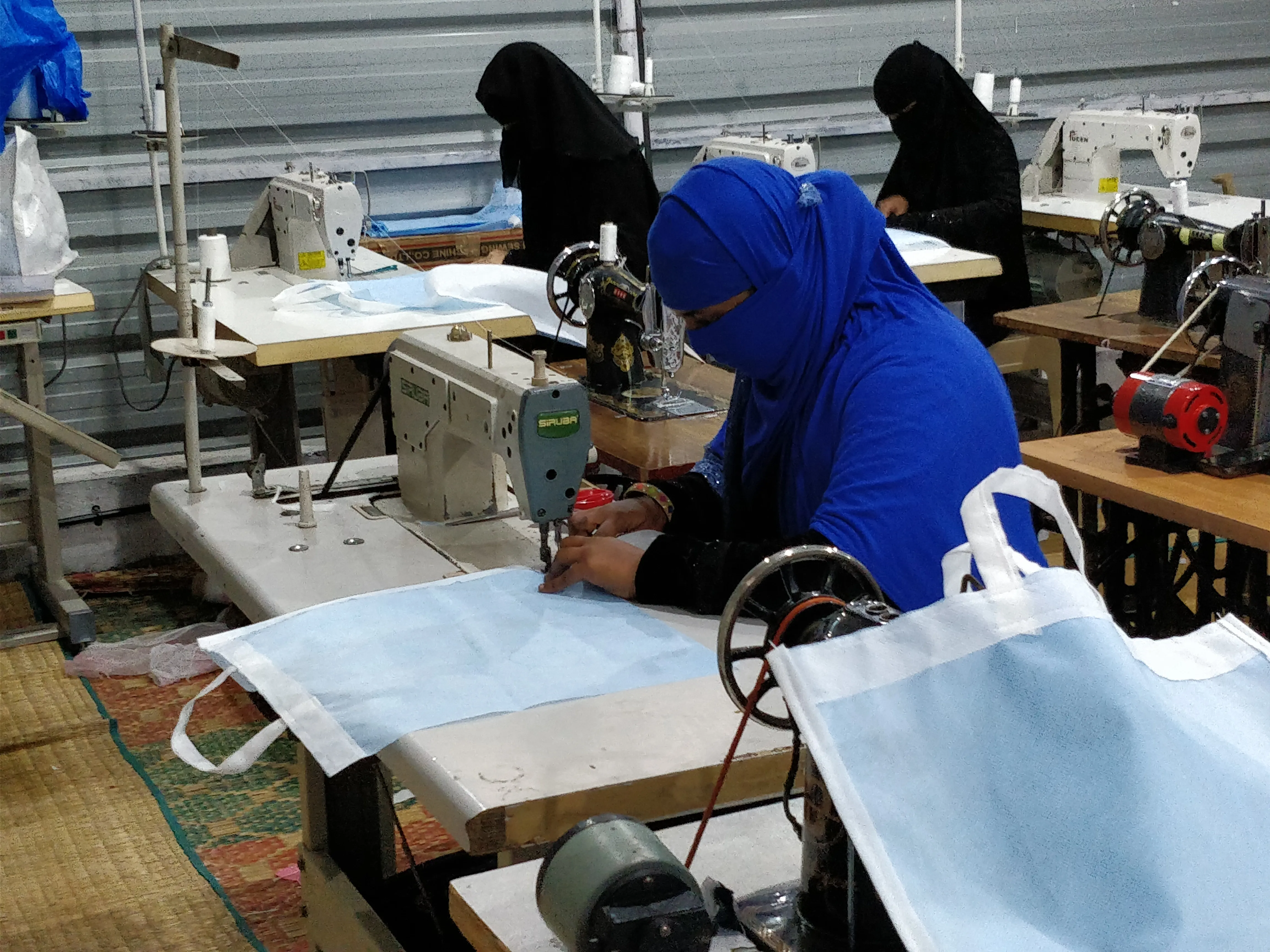 Women sewing at machines in a workshop.